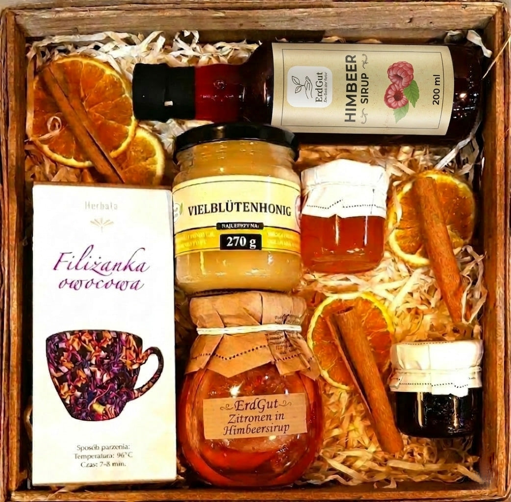 Geschenkkorb mit Tee, Sirup, Honig, Konfitüre und Zitronen in Sirup