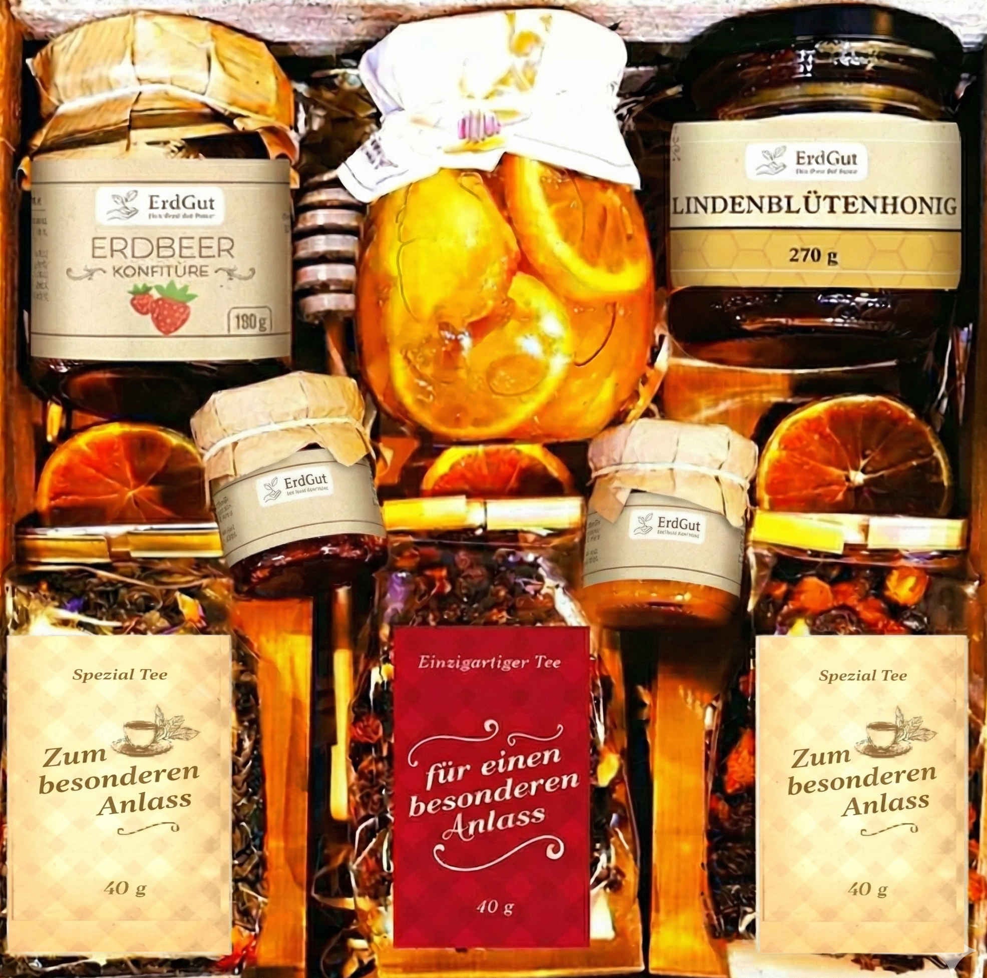 Geschenkkorb mit Tee, Honig, Konfitüre und Zitronen in Sirup