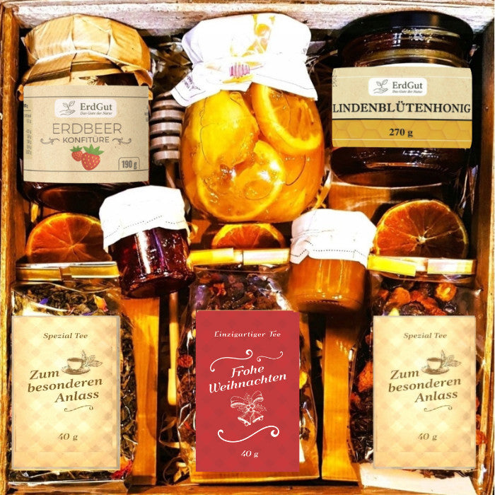 Geschenkkorb mit Tee, Honig, Konfitüre und Zitronen in Sirup